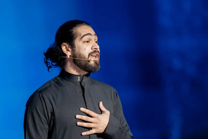 يزيد زيدان يتحدث على المسرح — Yazeed Zaidan speaking on stage